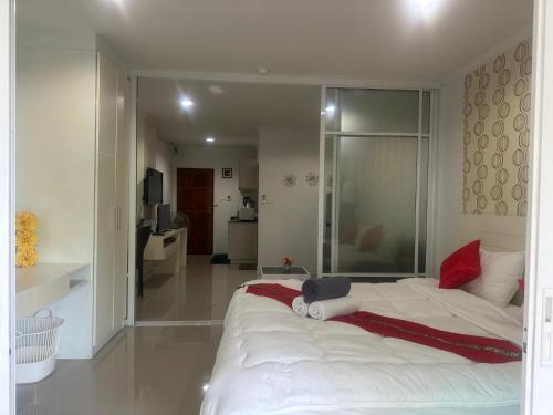 a bedroom with a large white bed with red pillows at Baan Klang Condo in Central Hua Hin in Hua Hin