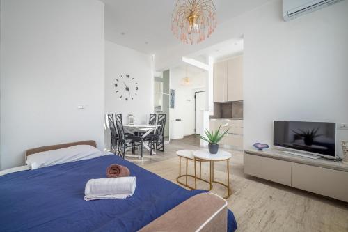 a bedroom with a blue bed and a dining room at Flower Apartment - Affitti Brevi Italia in Trieste