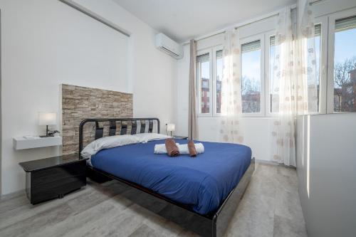 a bedroom with a bed with a blue comforter at Flower Apartment - Affitti Brevi Italia in Trieste
