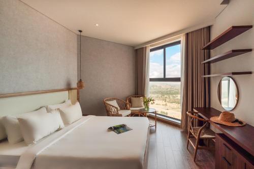 ein Schlafzimmer mit Bett, Schreibtisch und Fenster in der Unterkunft Mandala Sunrise Escape in Mui Ne