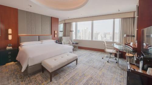 a hotel room with a bed and a desk and a window at Shanghai Marriott Marquis City Centre in Shanghai