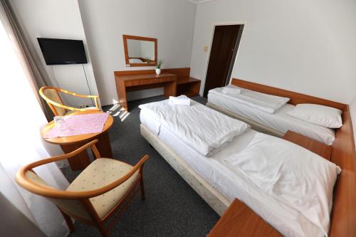 a hotel room with two beds and a chair at AGRO obiekt hotelowy in Wrocław