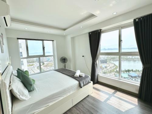 a bedroom with a large bed and large windows at Homestay Newlife Tower Vipp in Ha Long