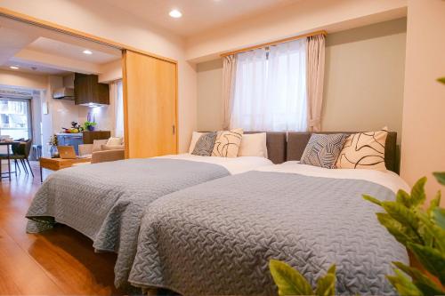a bedroom with two beds and a living room at Residence Hotel Ryogoku in Tokyo