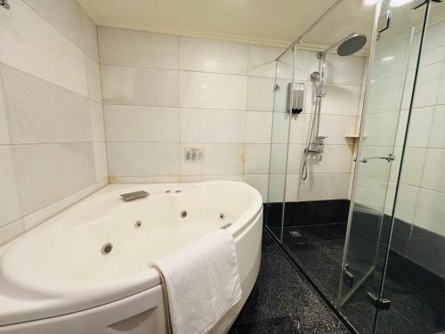 a white bath tub in a bathroom with a shower at Royal Seasons Hotel Taipei ‧ Nanjing W. in Taipei