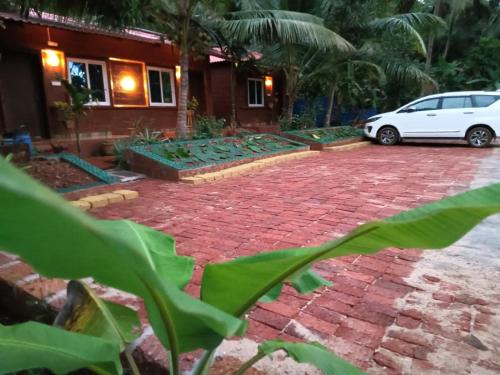 a car parked in front of a house with a brick driveway at New good vibes homestay in Honāvar
