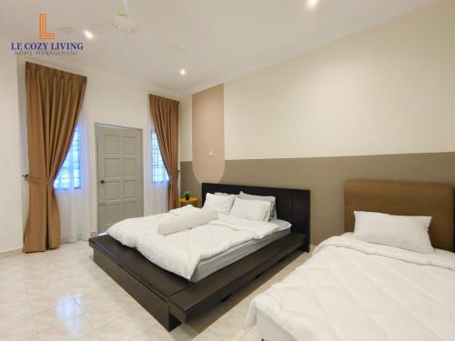 a bedroom with two beds with white sheets at The Cozy Retreat House at Bukit Mertajam in Bukit Mertajam