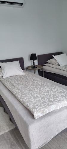a bedroom with two beds and a table with a lamp at Garden House in Pruszcz Gdański