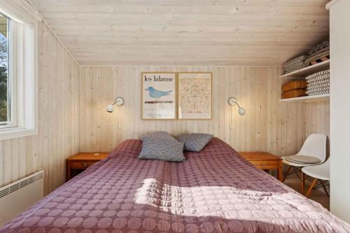 a bedroom with a bed with a purple comforter at Hyggeligt Sommerhus Med Havudsigt in Fåborg