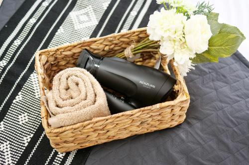 a basket with a blow dryer and a towel and flowers at Mr Kintaro Higashikomagata in Tokyo