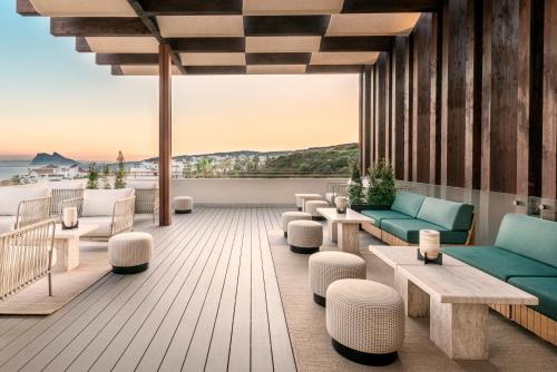 a rooftop patio with couches and tables and the ocean at Fairmont La Hacienda Costa del Sol in Alcaidesa