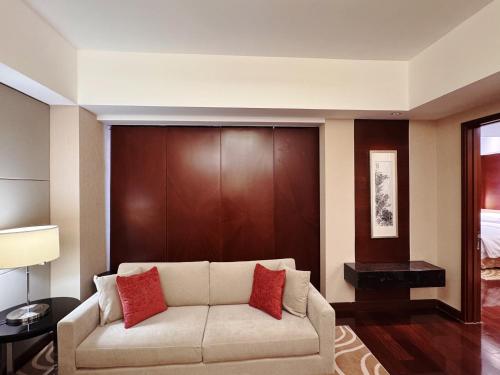 a living room with a couch with red pillows at The Imperial Mansion, Beijing - Marriott Executive Apartments in Beijing