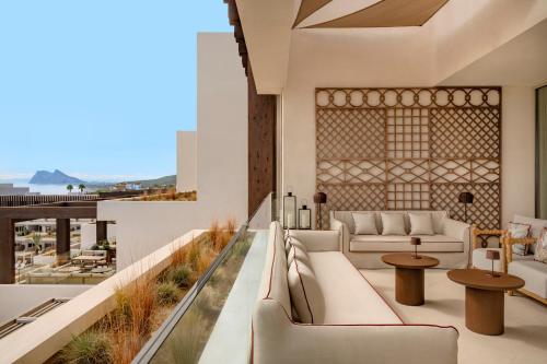 a living room with couches and tables on a balcony at Fairmont La Hacienda Costa del Sol in Alcaidesa