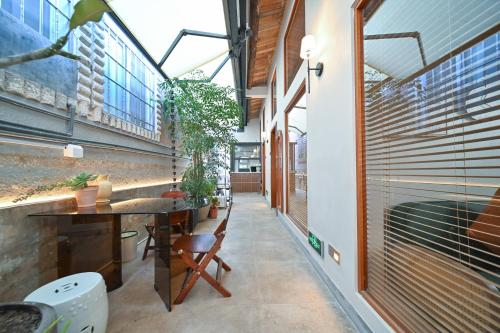 a corridor of a building with a table and chairs at 鼓浪屿古巷别苑旅馆 in Xiamen