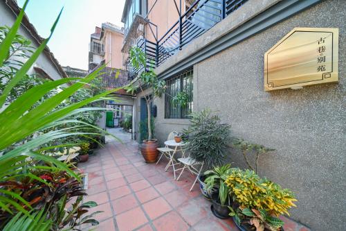 a courtyard of a building with plants and a window at 鼓浪屿古巷别苑旅馆 in Xiamen