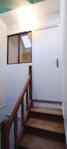 a stairway with a white door and a window at BiNiC ' ATTiC - Vue Mer - Centre Binic - Renove in Binic-Etables-sur-Mer