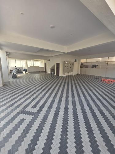 a large empty room with a blue and white floor at Blossom Service Apartment in Mysore