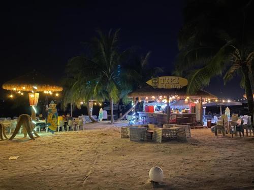 a beach with a restaurant with tables and chairs at night at Royal Strand Country Garden Danga Bay in Johor Bahru