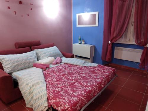 a bedroom with a bed with a red blanket at LA CASA DI CARTA red in Fiuggi