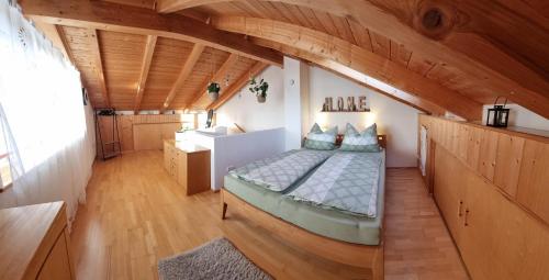 a bedroom with a bed in a room with wooden ceilings at AlzBlüte in Truchtlaching
