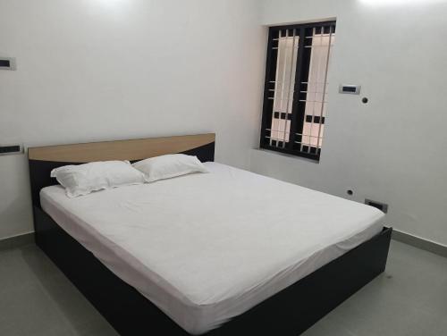 a bed with two pillows on it in a bedroom at Licence To Chill Homestay Villa in Pūvār