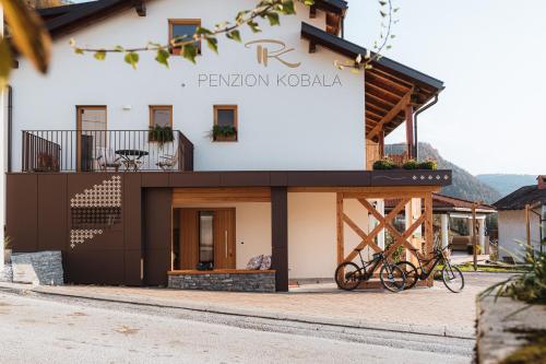 a building with two bikes parked outside of it at Hotel Penzion Kobala in Tolmin