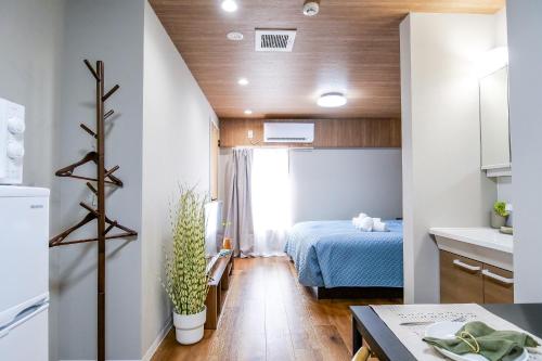 a small room with a bed and a kitchen at Maru 5 Inn in Tokyo