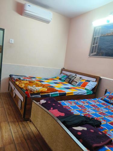 two twin beds in a room withthritisthritisthritisthritisthritisthritisthritisthritisthritis at Vyom homestay in Dwarka