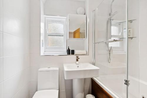 a white bathroom with a sink and a toilet at Free parking - Villa Apartment - Hosted by StaySejour in Brighton & Hove