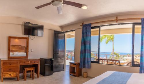 a bedroom with a bed and a view of the ocean at Hotel El Mirador in Puerto Escondido
