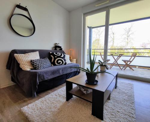 a living room with a couch and a table at Le Salluste cosy T2 with balcony in Strasbourg in Strasbourg
