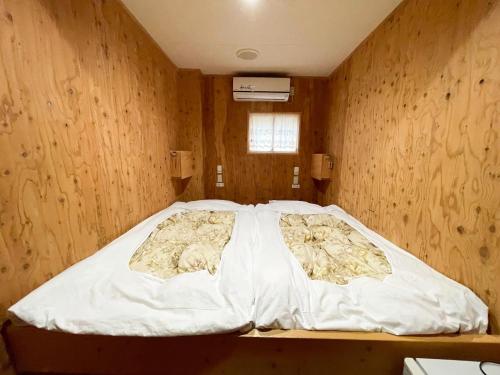 a large bed in a room with wooden walls at Guesthouse Otaru Wanokaze double room / Vacation STAY 32211 in Otaru