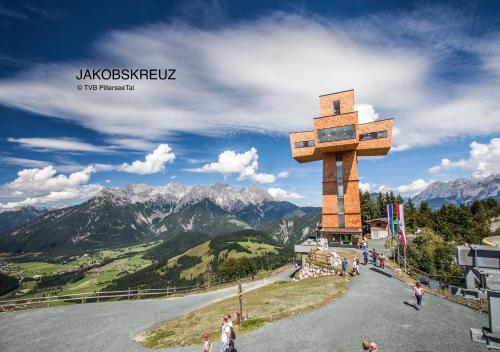 a large wooden cross on top of a mountain at Ferienwohnung Alpenglück in Sankt Jakob in Haus
