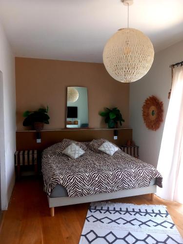 une chambre avec un lit et un lustre dans l'établissement Villa au coucher de soleil inoubliable sur les collines, à Vidauban