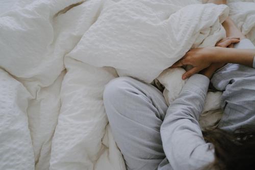 a person laying in bed with their hand on a pillow at Gästehaus Elisabeth in Oberaichwald