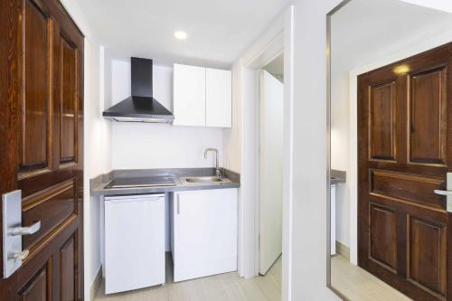 a small kitchen with a sink and a door at Elite Hotel Yalıkavak in Yalıkavak