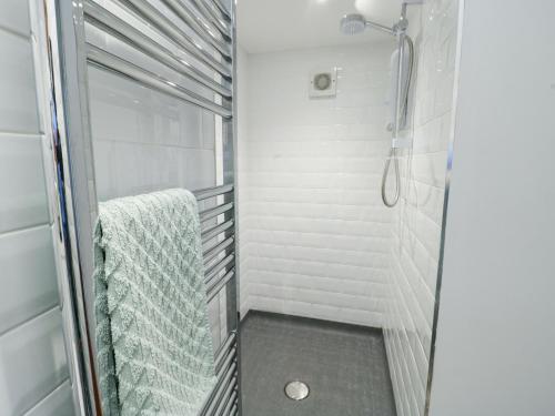a walk in shower in a bathroom with white walls at Old Tollgate in Holyhead
