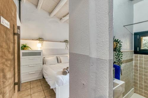 a small bedroom with a bed and a shower at Mas Tarres L'olivera Madremanya in Madremanya