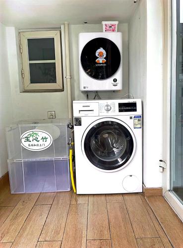 a washing machine with a microwave on top of it at 哲帆民宿花园洋房江与城店 in Chongqing