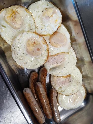 a tray of eggs and sausages and sausage at APARTMÁN POHODA in Svatava