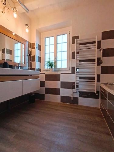 - une salle de bains avec des bandes noires et blanches sur le mur dans l'établissement LE JARDIN DE LA PICHONNERIE Chambres d'hôtes, à Thésée