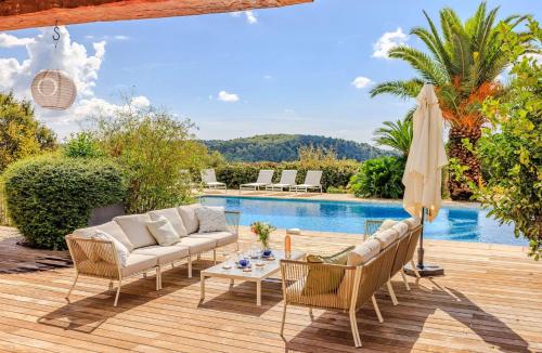 une terrasse avec un canapé et des chaises ainsi qu'une piscine dans l'établissement Villa Aqui, à Tourrettes-sur-Loup