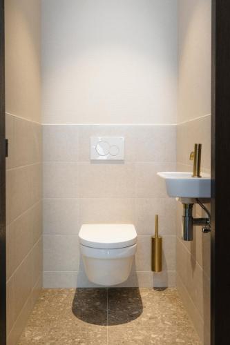 a bathroom with a toilet and a sink at Hotel Philippe Suites I Kloeg Collection in Philippine