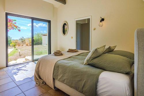 une chambre avec un grand lit et une grande fenêtre dans l'établissement Villa Aqui, à Tourrettes-sur-Loup