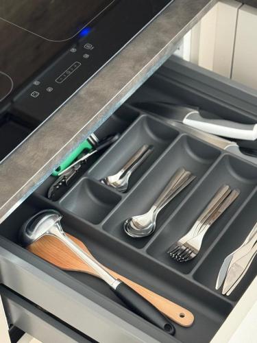 a drawer filled with utensils in a dishwasher at Villa Betty Apartments in Arco