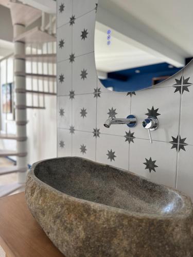 - une grande baignoire en pierre dans une pièce dotée d'étoiles sur le mur dans l'établissement Loft house in Bayeux Historic Center, à Bayeux