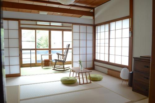 a room with a room with a table and windows at 湯治宿かふね in Yugawara