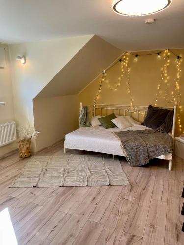 a bedroom with a bed with lights on the wall at A Studio That Warms the Soul in Tapa