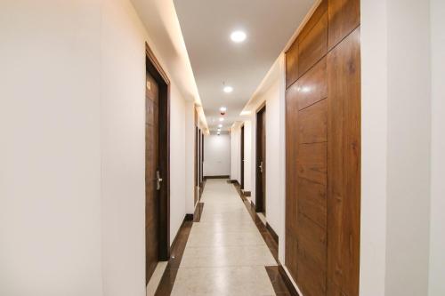 a hallway with wooden doors and a hallway with white walls at FabHotel Prism Grand in Zirakpur