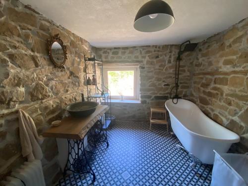 a bathroom with a bath tub and a sink at Ta Petrina Cottage in Selishte